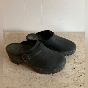 All black Swedish clogs with adjustable heel strap. Size 39